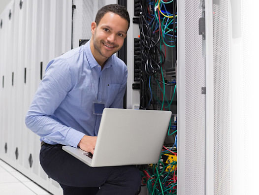 IT contractor working on a server with a laptop