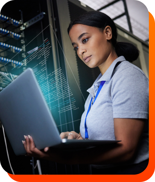 Female IT support engineer in working on a laptop in a server room